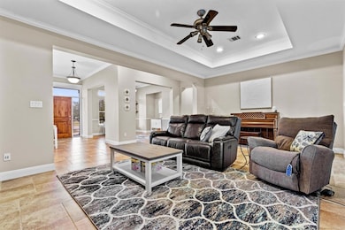 Living area with crown molding, a raised ceiling,