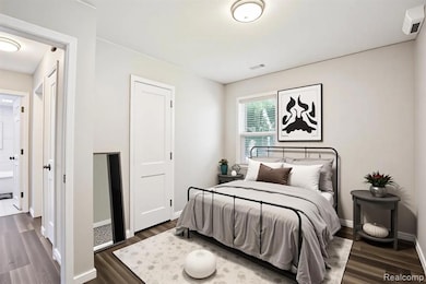 Bedroom with dark wood-type flooring and baseboards
