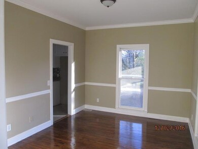 The spacious dining room adjacent to the kitchen has newly refinished wood floors.
