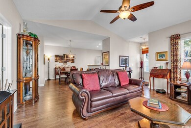 Living room with ceiling fan with notable chandeli
