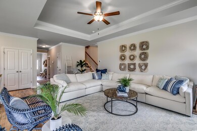 Living room featuring crown molding, ceiling fan, 