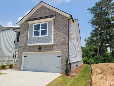 View of front of house featuring a garage, concrete driveway, and brick siding
