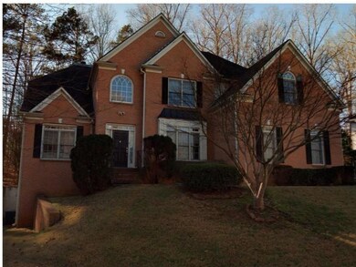 Traditional-style house with brick siding and a front lawn