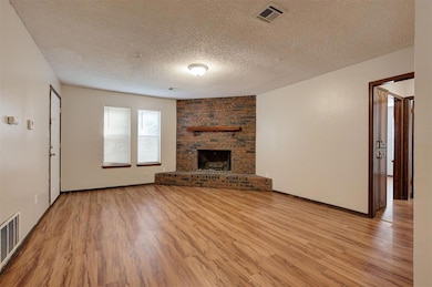 Unfurnished living room with a brick fireplace, li