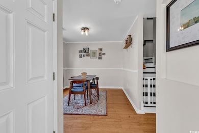 Dining room featuring crown molding, light wood-st