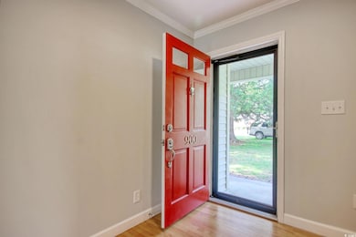 Entrance foyer featuring light wood-style floors, baseboards, and ornamental molding