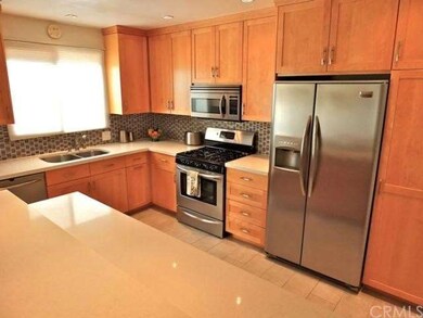 Elegant kitchen boasts custom maple cabinetry, qua
