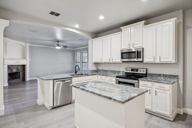 Kitchen with appliances with stainless steel finishes, a peninsula, light stone countertops, open floor plan, and recessed lighting