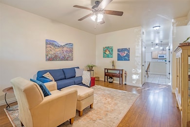 Living area featuring wood finished floors and a ceiling fan