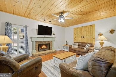 Upgraded living room featuring hardwoods, wood-burning gin fireplace, and stunning wood ceiling to accentuate the balance between rustic and craftsman charm.