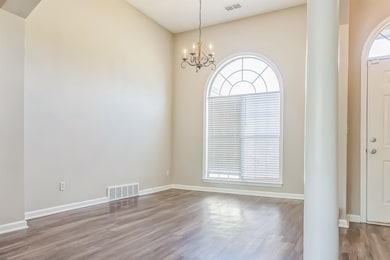 Interior space featuring visible vents, a chandeli