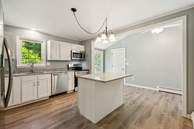 Beautifully remodeled kitchen with brand new cabinets, gorgeous granite counters, stainless steel appliances, an island, and an abundance of cabinet and counter space
