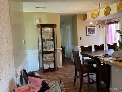 Dining room with dark wood-type flooring, a notabl