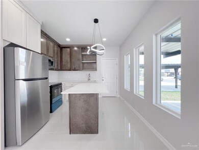 Kitchen featuring dark brown cabinets, open shelves, a sink, light countertops, and stainless steel appliances