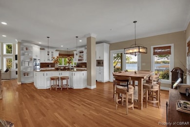 Dining area with recessed lighting and light wood-
