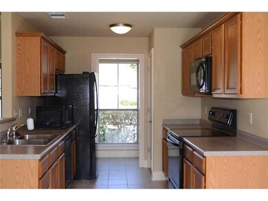 Kitchen. Wood cabinets, ceramic tile and the refri