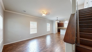 Unfurnished living room featuring dark wood-style flooring, crown molding, stairway, a chandelier, and a ceiling fan