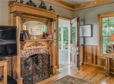 The gas-log fireplace is showcased by the double antique mantel with oval mirror detail.