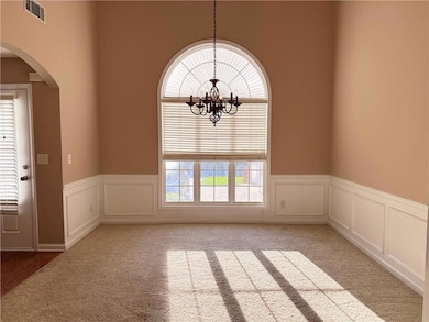 Spare room featuring arched walkways, carpet floor