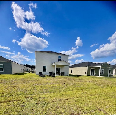 Rear view of house featuring a lawn
