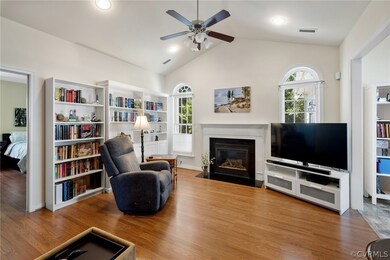Great room with vaulted ceiling, ceiling fan w/ lights, and upgraded mantel with marble surround and hearth