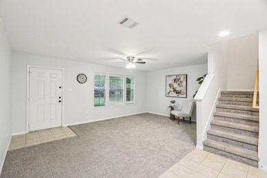 Entrance foyer with light colored carpet, stairwa