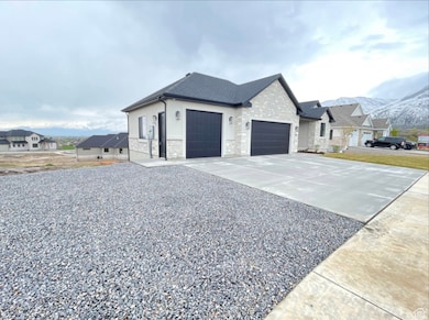 View of home's exterior with concrete driveway, an attached garage, stone siding, and a mountain view