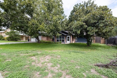 Obstructed view of property with a garage, brick siding, and driveway