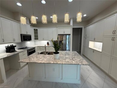 Kitchen featuring decorative backsplash, appliances with stainless steel finishes, light stone countertops, light marble finish floors, and recessed lighting