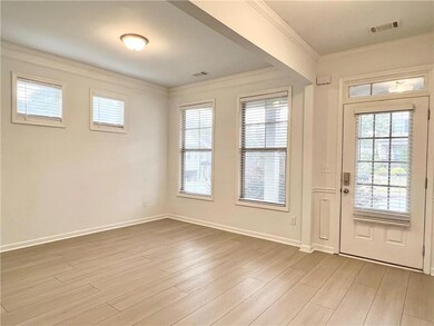 Entryway with crown molding and wood finished floors