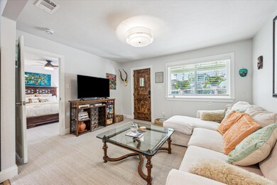Carpeted living area featuring a ceiling fan and 