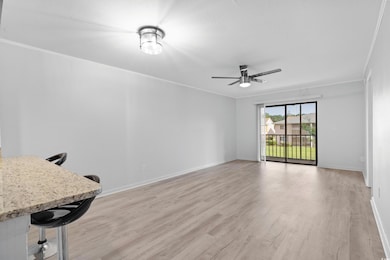 Unfurnished living room with ceiling fan, crown mo