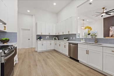 Kitchen with electric range, a sink, light counter