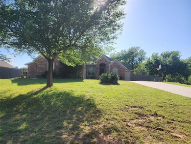 View of front facade with brick siding, driveway, and an attached garage