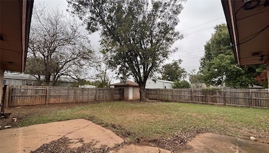 Fenced backyard featuring a shed