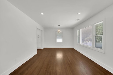 Unfurnished dining area featuring dark wood-style flooring and recessed lighting