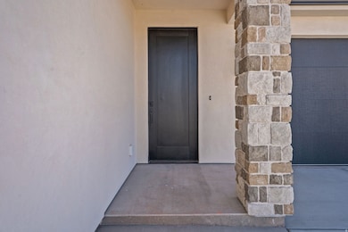 View of exterior entry with stone siding and stucco siding