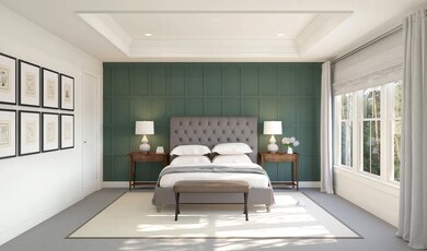 Primary suite with tray ceiling, crown moulding and decorative feature wall