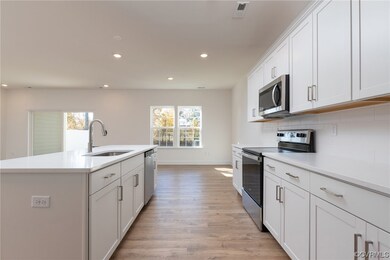 Kitchen featuring sink, an island with sink, light