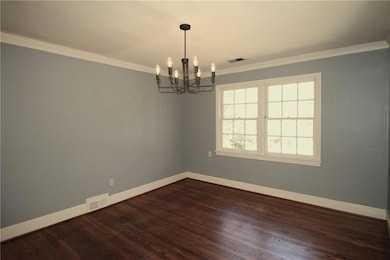 Empty room with an inviting chandelier, crown mold