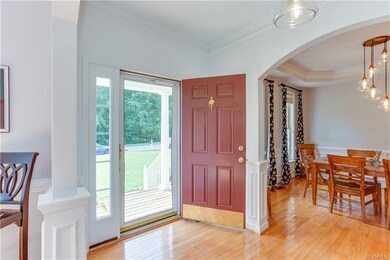 Open and bright foyer with exquisite wood work and arched openings to adjoining rooms.