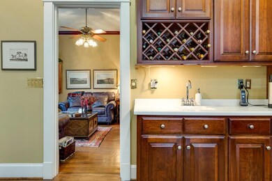 Bar area off gathering room with sink, built in wine rack, storage