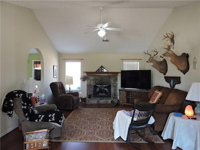 Ranch-style home with a front yard, an attached ga