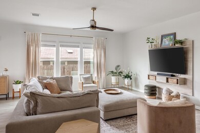 Living area with baseboards, ceiling fan, visible