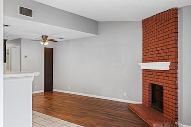 Unfurnished living room with a fireplace, wood finished floors, and ceiling fan