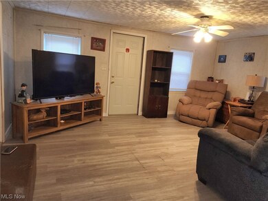Living room with ceiling fan and light hardwood / wood-style floors