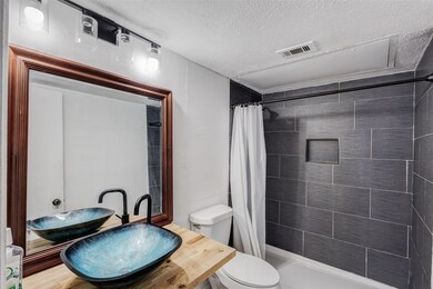 Bathroom with visible vents, toilet, a stall showe