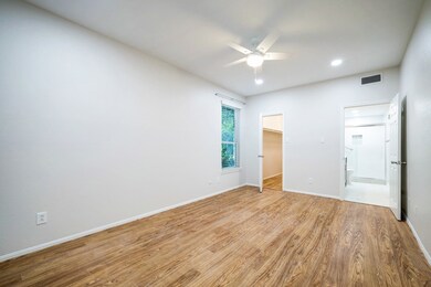 Bedroom has walk-in  closet and window with blinds