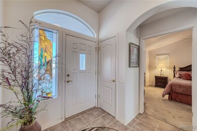 Foyer with light carpet and vaulted ceiling