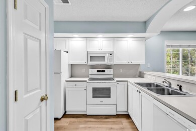 Kitchen featuring light countertops, white cabinet